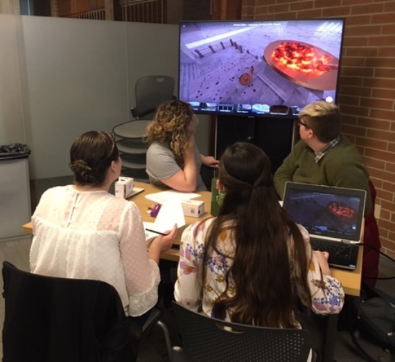 History students viewing an ancient site using a VR rendering.