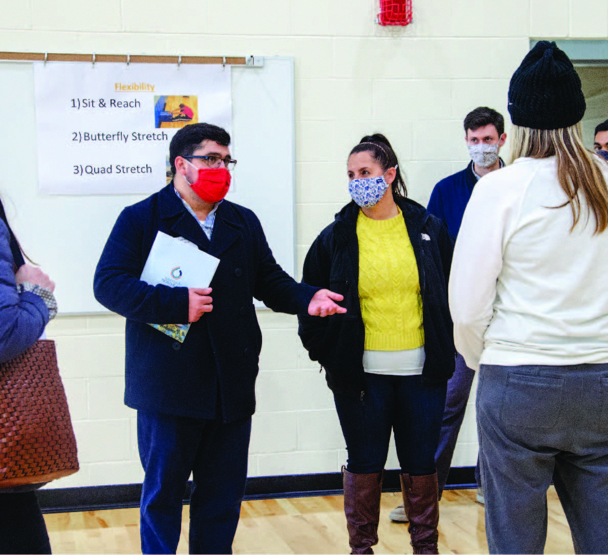 Faculty and staff in discussion inside the Shaw middle school gym. 
