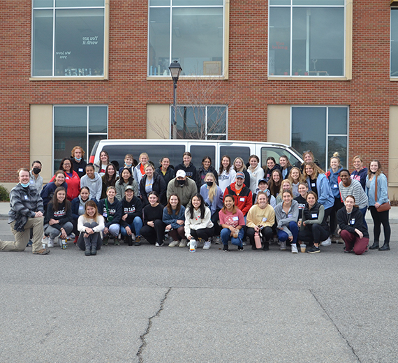 A group of around 70 Gonzaga Students pose in front of the Hemmingson building mid morning, waiting to be transported to their service sites. 