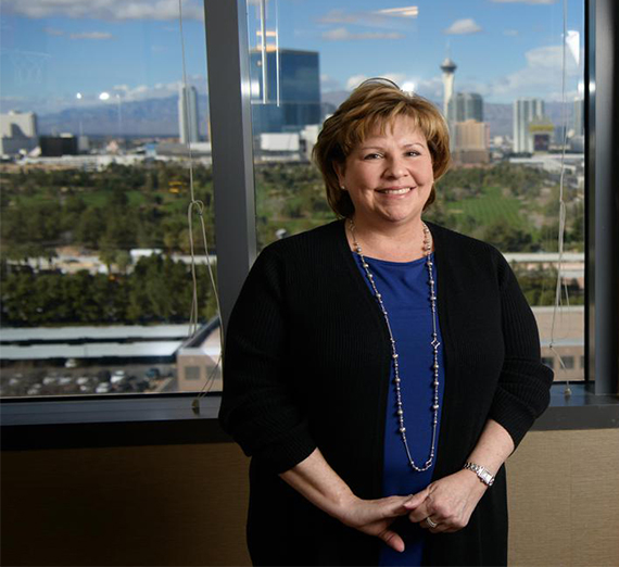 Reuther stands in front of window looking over Vegas