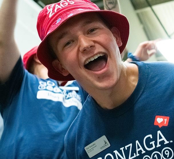 Tyler Gonzalez smiles into the camera while wearing a red bucket hat during GEL Weekend.