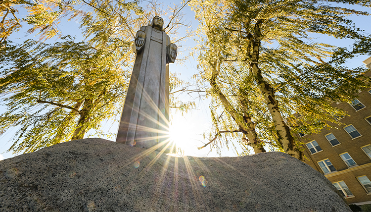 aluminum jesus sculpture backlit by sun
