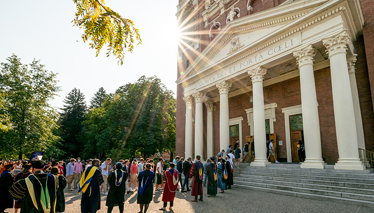 faculty lining up at St. Aloysius church backlit by sun