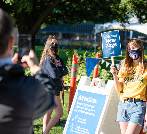 student welcoming new Zag and parent taking photo