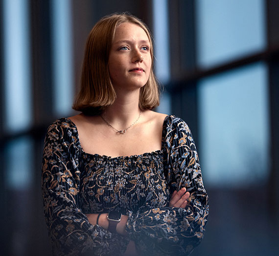 Senior Maddie Sontag stands in front of windows