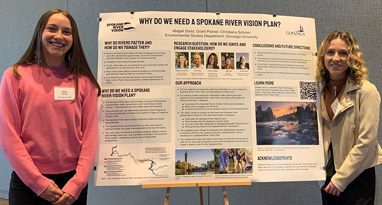 Abby Dodd and Christiana Schmer stand beside the Spokane River Vision Plan poster board.