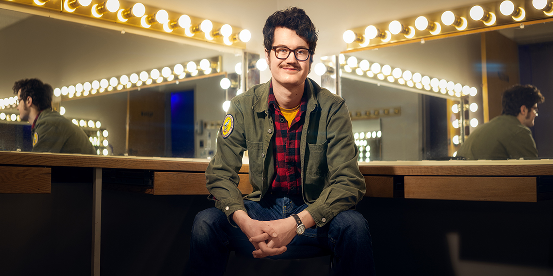 Pete King sits in front of mirrors surrounded by light bulbs