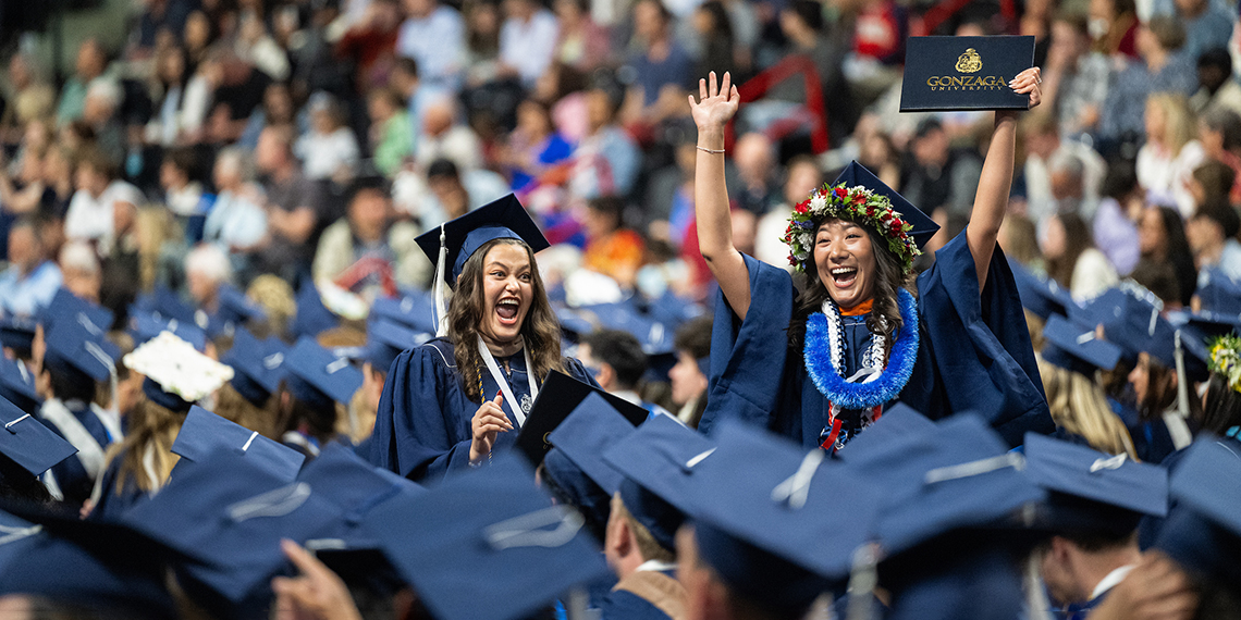 Students in graduation regalia cheer
