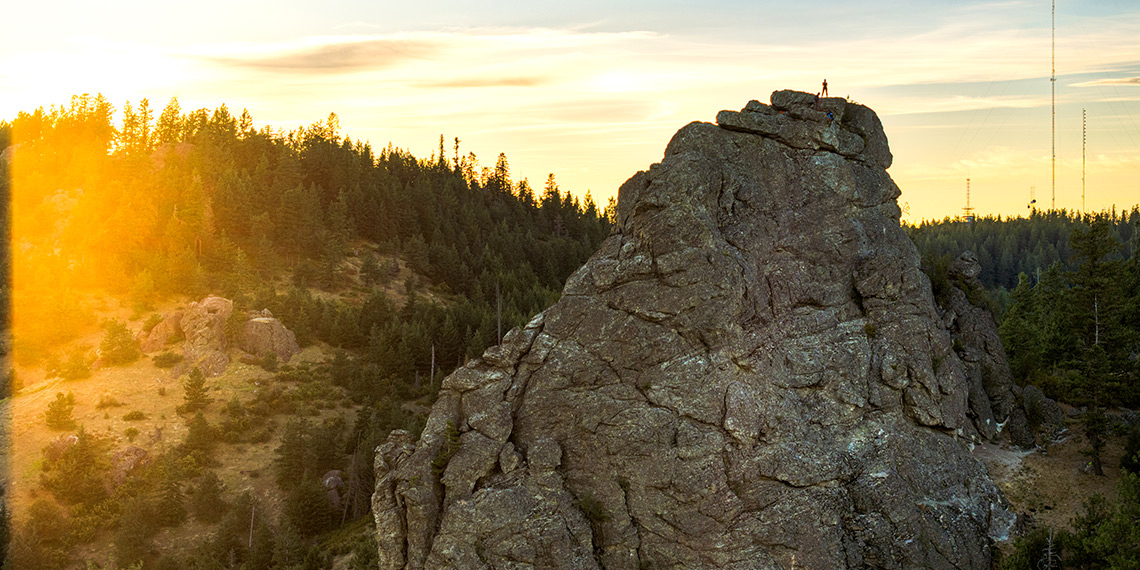 A climber from Gonzaga's Immersive Outdoor Learning program stand atop the Rocks of Sharon.