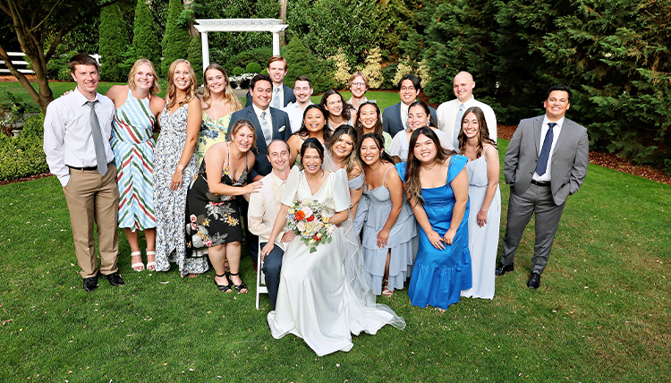 A group of people smile and pose at a wedding,