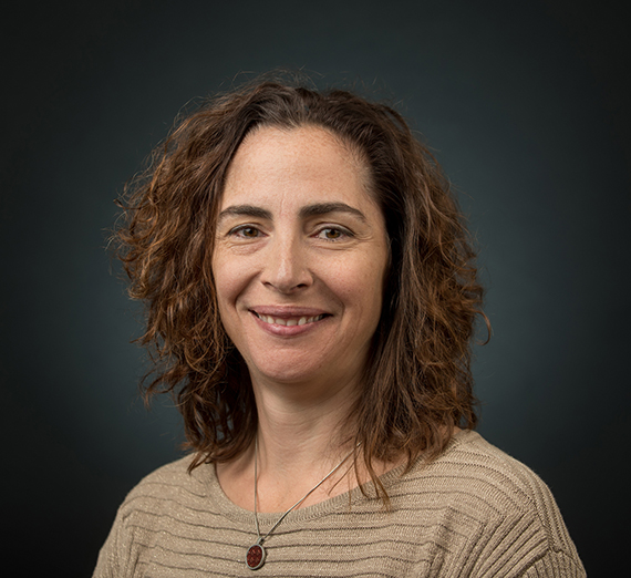 A woman with curly brown hair smiling