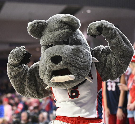 Gonzaga's mascot Spike flexs for the camera during a basketball game.