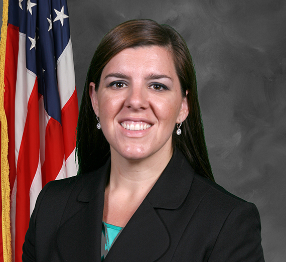 Carrie Braun in front of a grey background and American flag