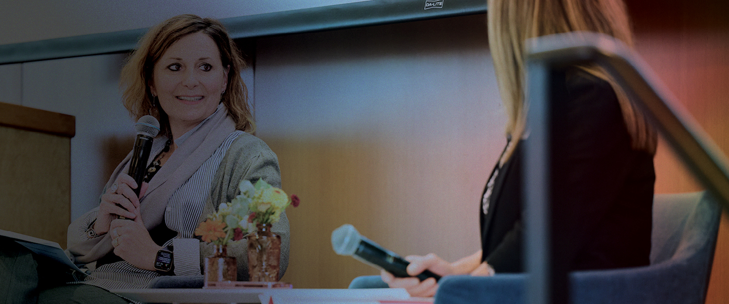 Gonzaga President Passerini and student having a discussion on a stage with microphones.